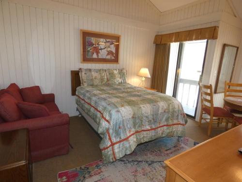 ein Schlafzimmer mit einem Bett, einem Stuhl und einem Schreibtisch in der Unterkunft Sanctuary at Sudendorf in Bellaire