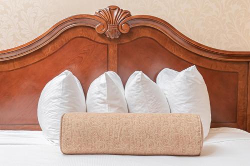 a bed with a wooden head board with white pillows at Fulton Steamboat Inn in Lancaster