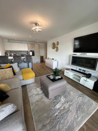 a living room with a couch and a tv at Waterfront - long stay apartment in Southampton