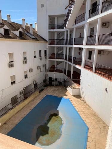 a pool of water in the courtyard of a building at Apto residencial piscina centro-Parking in Jaén