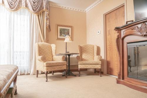 a room with two chairs and a table and a fireplace at Fulton Steamboat Inn in Lancaster