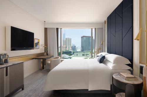 a hotel room with a large bed and a large window at Kimpton Naluria Kuala Lumpur by IHG in Kuala Lumpur