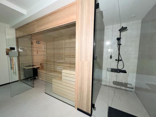 a walk in shower with a glass door at Minka - nordic cabin hideaway in Poiana Micului