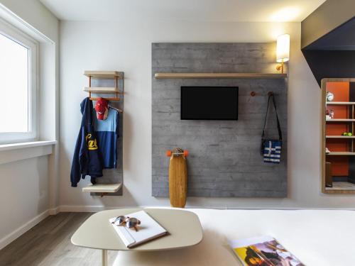 a living room with a wall with a tv at Ibis Budget Strasbourg Centre Republique in Strasbourg