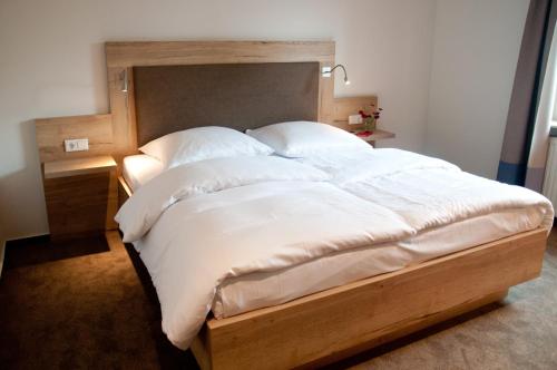 Angler Hof في Süderbrarup: سرير كبير بملاءات ووسائد بيضاء