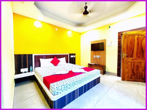 a bedroom with a bed and a yellow wall at Hotel S - Sashi Near Sea Beach and Jagannath Temple - Bangali Market - Fully Air Conditioned Hotel - Prime Location Spacious Room - A Budget Hotel In Puri in Puri
