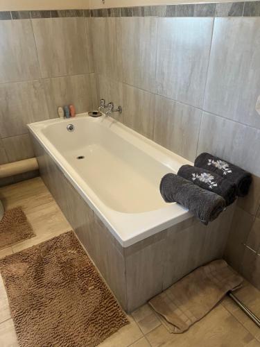 a white bath tub in a bathroom with a rug at Modern Style Apartments, An Escape From The City in Pretoria