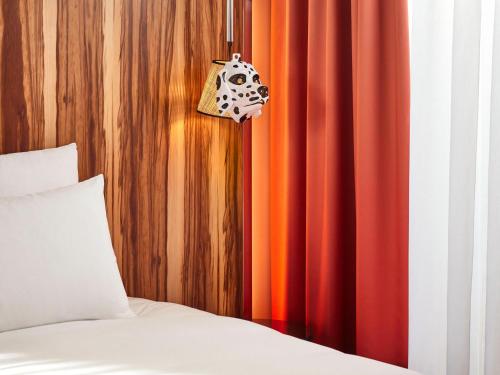 a bedroom with a bed and red curtains at Mama Shelter Rennes in Rennes