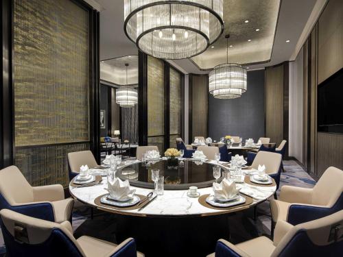a dining room with a large table and chairs at Sofitel Xiong An in Baoding