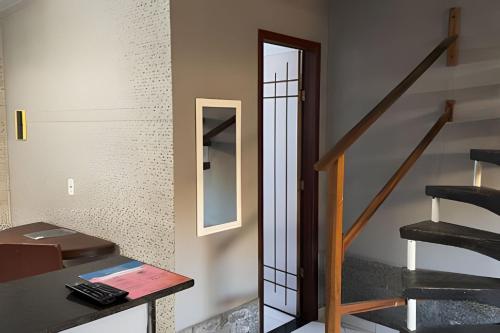 a room with a staircase with a mirror and a table at Duplex em Itaúna 4min da Praia que ocorre o WSL, 1min da pista de skate do LS, pracinha com parque infantil, quadra de futebol, tudo isso a 1 min da duplex, perto do comércio, wi-fi super rápido, estacionamento gratuito, monitoramento 24hrs in Saquarema