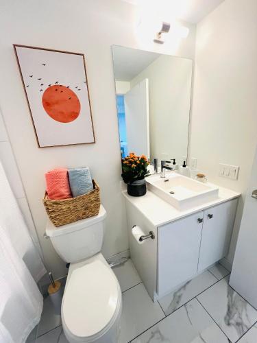 a bathroom with a white toilet and a sink at Lakeview Steps to the lake & just minutes to downtown in Toronto
