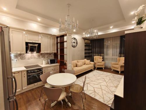 a kitchen with a table and chairs in a room at Двухкомнатная квартира студия in Almaty
