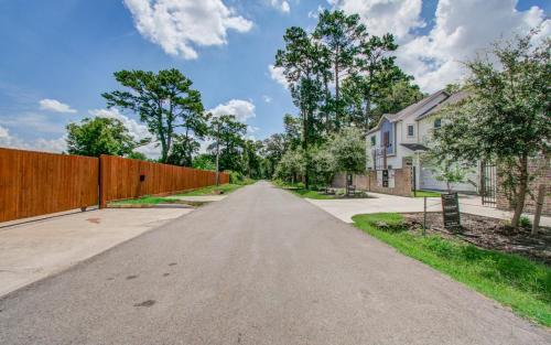 an empty road in front of a fence at Colorful Dining Experience in Cozy Getaway in Houston