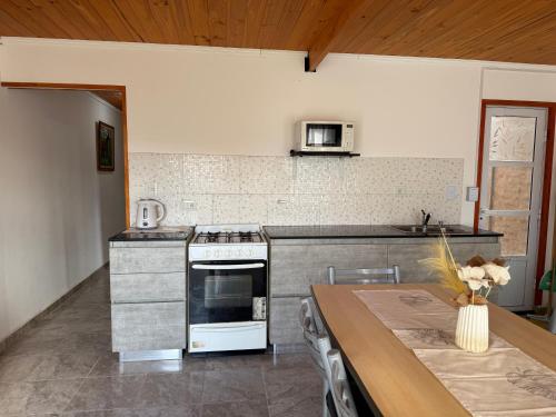 una cucina con piano cottura e tavolo di Casa M&M a Puerto Madryn