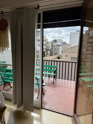 a balcony with a bench and a view of a city at Departamento para 3 personas a 1 cuadra de la playa in Mar del Plata