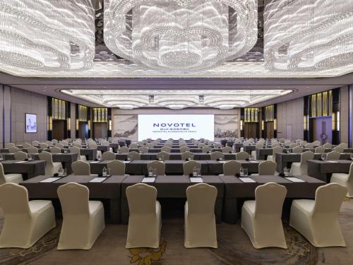 a conference room with a large table and chairs at Novotel Kunshan Yangcheng Lake in Kunshan