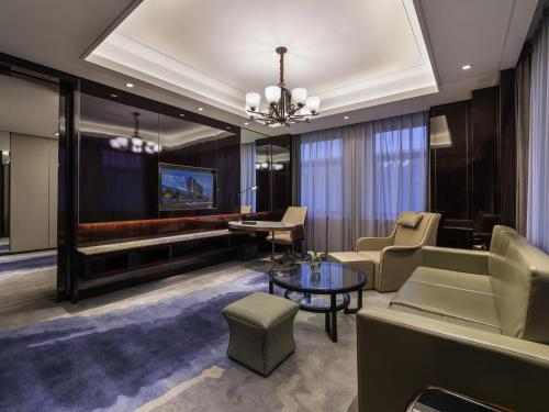 a living room with a couch and a table at Novotel Kunshan Yangcheng Lake in Kunshan