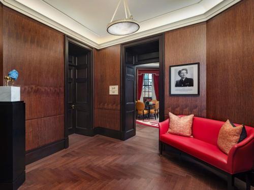 a living room with a red couch and wooden walls at Raffles London at The OWO in London