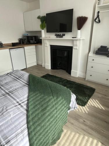 a living room with a bed and a tv on a fireplace at 1st Floor 1 Bed Studio in Weston-super-Mare