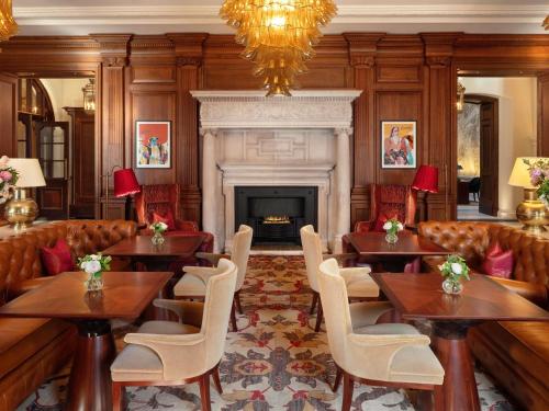 a restaurant with tables and chairs and a fireplace at Raffles London at The OWO in London