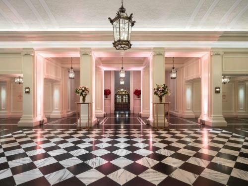 a lobby with a checkered floor and a chandelier at Raffles London at The OWO in London