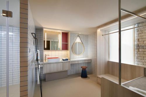 a bathroom with a shower and a sink and a mirror at Shama Yen-Akat Bangkok in Bangkok