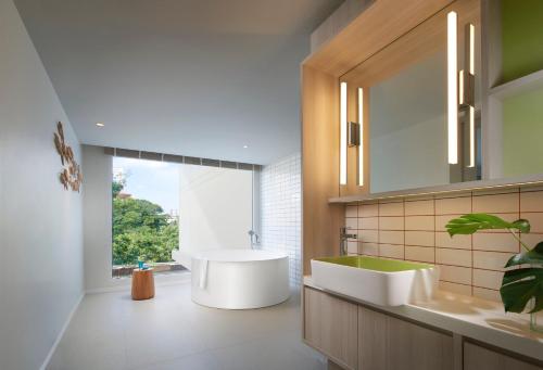 a bathroom with a white tub and a sink at Shama Yen-Akat Bangkok in Bangkok
