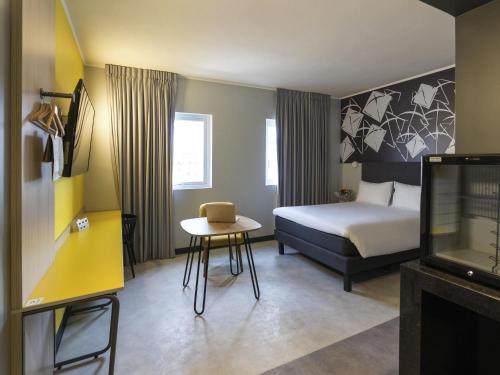 a bedroom with a bed and a table and a tv at ibis Styles Antofagasta in Antofagasta