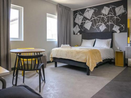 a bedroom with a bed with a black and white wall at ibis Styles Antofagasta in Antofagasta