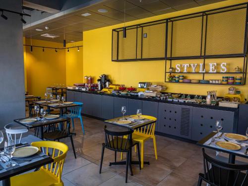 a restaurant with tables and chairs in front of a counter at ibis Styles Antofagasta in Antofagasta