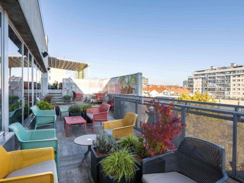 a balcony with colorful chairs and tables on a building at ibis Styles Ljubljana Centre in Ljubljana