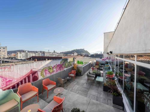 a rooftop patio with chairs and tables on a building at ibis Styles Ljubljana Centre in Ljubljana
