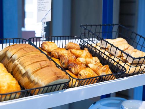 a bunch of pastries in baskets on a shelf at ibis budget Tours Sud in Chambray-lès-Tours