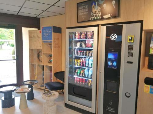 a large soda vending machine in a store at ibis budget Tours Sud in Chambray-lès-Tours