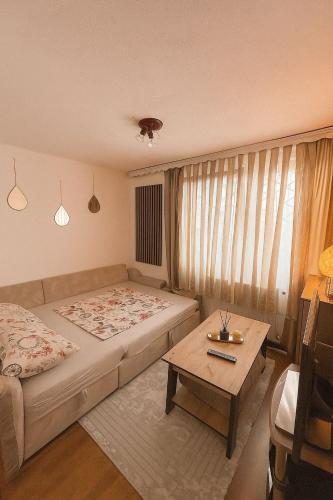 a bedroom with a bed and a coffee table at Apartman Rejjan in Zenica
