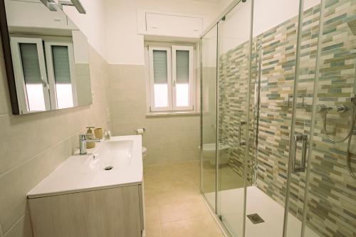 a bathroom with a sink and a glass shower at The Best Bed & Breakfast in Amantea
