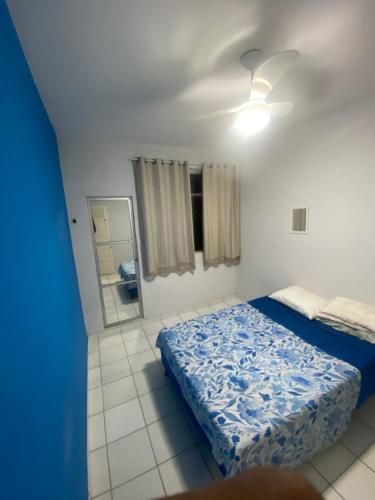 um quarto com uma cama azul e um espelho em Quarto Suíte Orla Salvador BA em Salvador