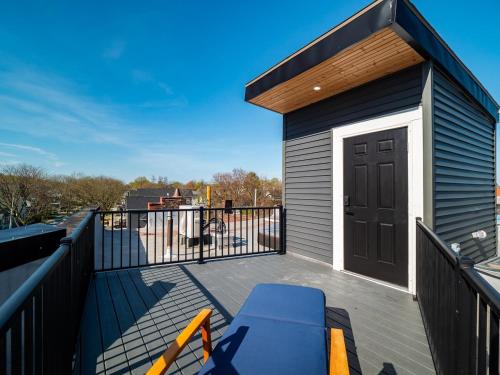 a deck with a blue bench and a black door at Stunning Boho Apt in Ohio City in Cleveland