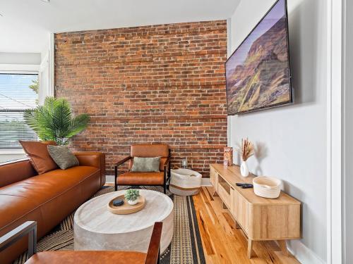 a living room with a couch and a brick wall at Stunning Boho Apt in Ohio City in Cleveland