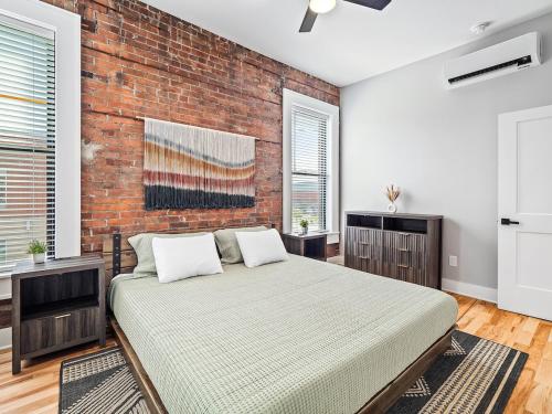 a bedroom with a bed and a brick wall at Stunning Boho Apt in Ohio City in Cleveland
