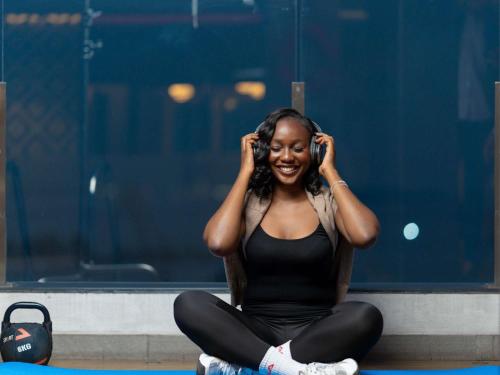 a woman sitting on the floor listening to headphones at Novotel Kinshasa La Gombe in Kinshasa