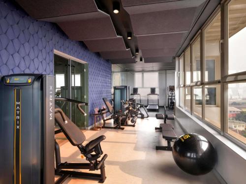 a gym with a row of treadmills and chairs at Novotel Kinshasa La Gombe in Kinshasa