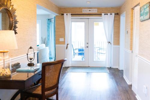 a living room with a desk and a table at Tidewater I102 - Beautiful Oceanview! First Floor Walkout! in Isle of Palms
