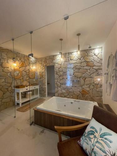 una grande vasca da bagno in una stanza con un muro di pietra di Villa kite a Itarema