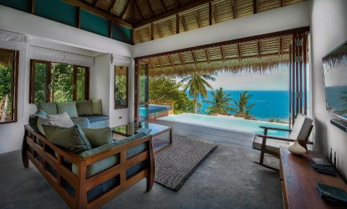 a living room with a couch and a swimming pool at Phandara Luxury Pool Villas in Koh Tao