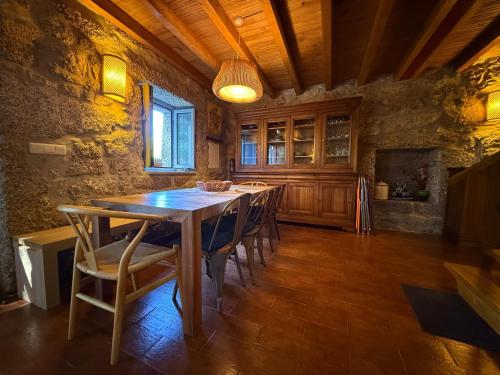 a dining room with a wooden table and chairs at Casa Museu Lagar de Azeite in Terras de Bouro