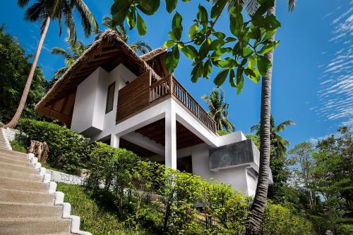 a house on a hill with stairs and palm trees at Phandara Luxury Pool Villas in Koh Tao