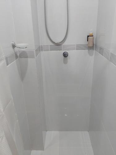 a white bathroom with a shower with a mirror at Luxotel Business Chincha in Chincha Alta