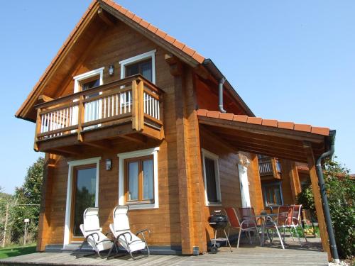 a house with a deck and chairs in front of it at Ferienhäuser Aura in St. Andrä am Zicksee