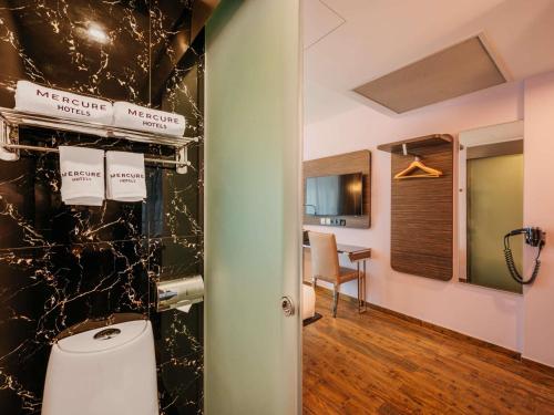 a bathroom with a toilet in a room at Mercure Singapore Tyrwhitt in Singapore